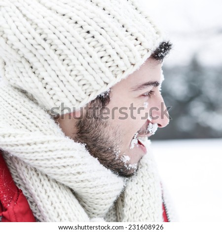 Man in winter with snow in his face at a snowball fight