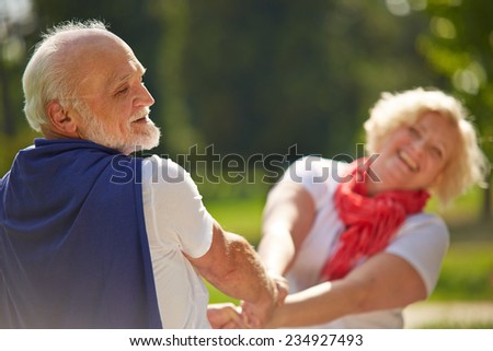 Old senior couple dancing happy together in nature