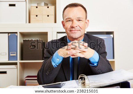 Accountant sitting at his desk in the office with files and a calculator
