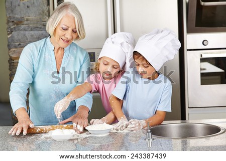 Family with grandmother and children baking christmas cookies in kitchen