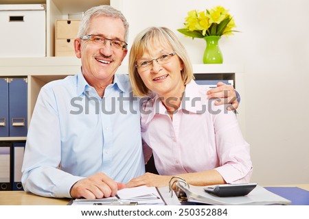 Happy senior couple with files and folders sitting at a desk