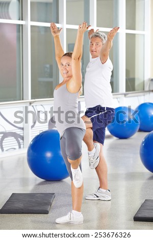 Two happy senior people exercising together in a gym
