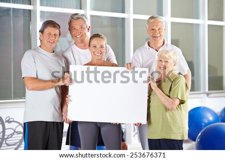 Group of happy senior people holding empty white advertising sign
