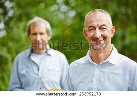 Two senior men together in summer in nature
