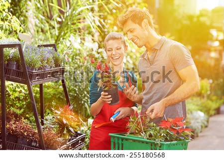 Saleswoman giving advice to customer in a flower shop in summer