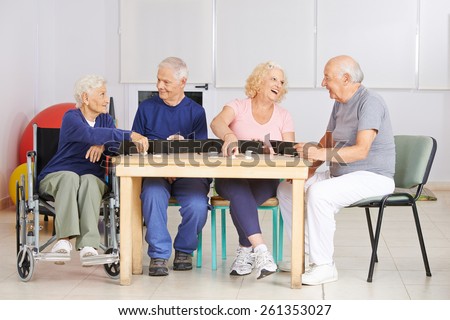 Happy group of senior people playing rummy game in a nursing home