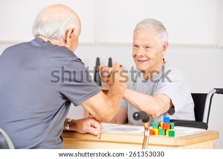Two old senior men holding hands for congratulation in a nursing home