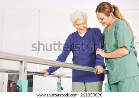 Physiotherapist helping old senior woman on treadmill with handles
