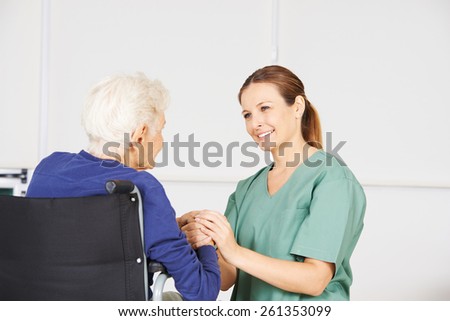 Old woman in a wheelchair as patient with geriatric nurse in a nursing home