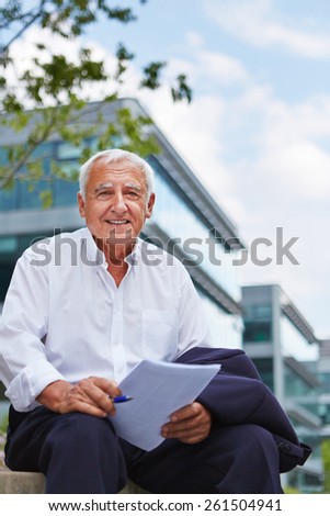 Happy old lawyer with contract sitting outside in summer