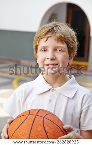 Child with basketball in physical education class in school