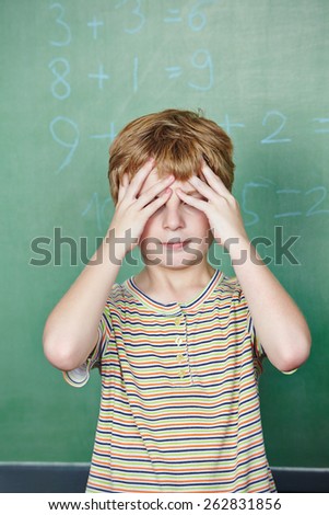 Elementary school student in front of chalkboard in math class