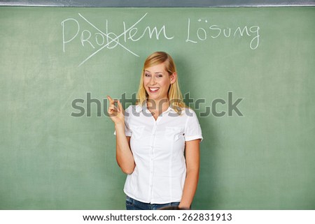 Woman in front of blackboard with german words for problem and solution written on it