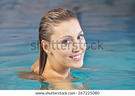 Happy young woman doing aqua fitness in a swimming pool