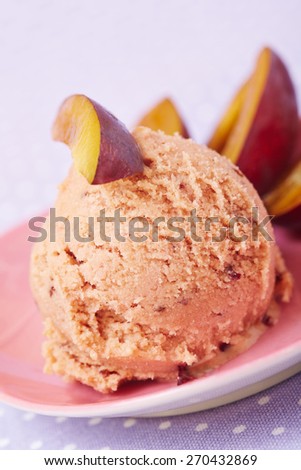 Homemade scoop of plum ice cream with fresh sliced plums