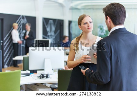 Man and woman in office talking to each other in a break