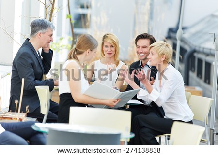 Group of people talking about business outdoors in a coffee shop