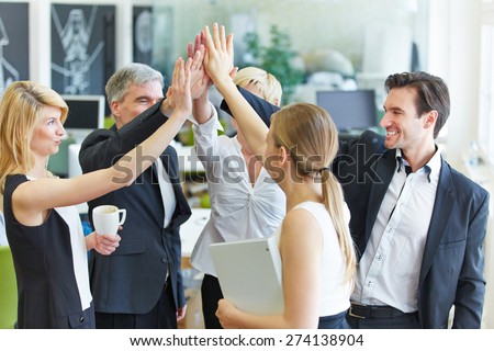Happy business team making high five with their hands in the office