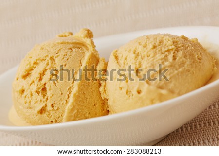 two scoops of homemade caramel ice cream in a bowl