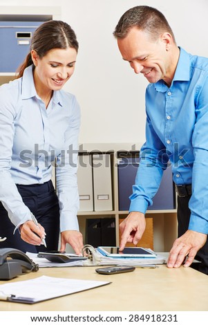Business people in office planning financing with a tablet computer