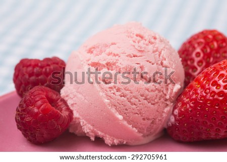 Scoop of homemade raspberry ice cream with strawberries and raspberries