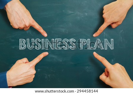 Many hands pointing to business plan on a chalkboard