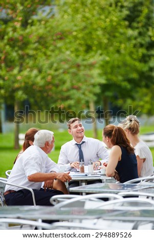 Business team having a meeting outdoors in a restaurant in summer