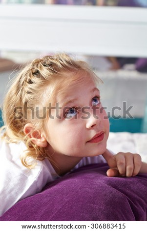 Blond pensive girl in bed thinking in her nursery