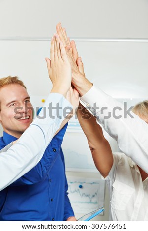 Businesspeople clapping hands to give high five in the office