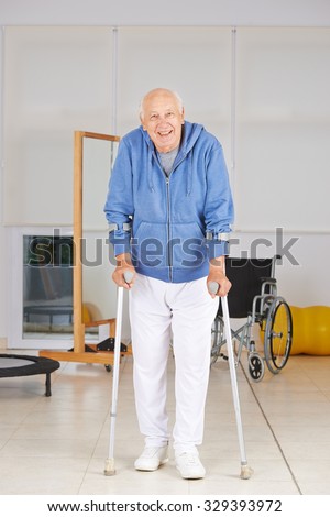 Old senior man walking with crutches in physiotherapy