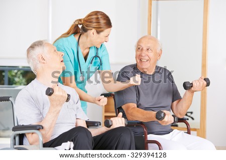 Geratric nurse motivating senior men in wheelchairs in physiotherapy