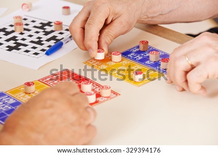 Hands of senior people playing Bingo together in a nursing home