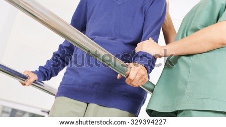 Hands of old woman on handles of a treadmill in physiotherapy