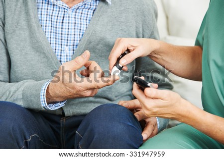 Blood glucose monitoring on finger of senior man with diabetes