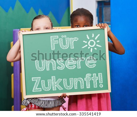Children holding chalkboard with German slogan \