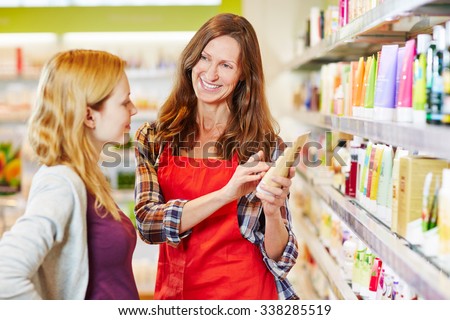 Woman in drugstore gets advice from saleswoman while shopping for cosmetics