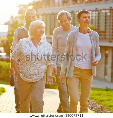 Happy senior travel group walking in a city in summer