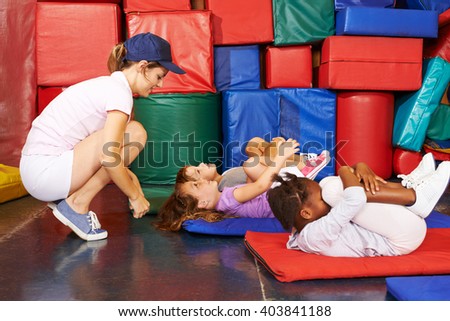 Group of children doing gymnastics in preschool with PE teacher