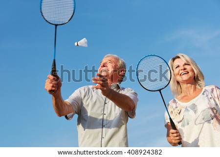 Happy couple playing badminton in summer