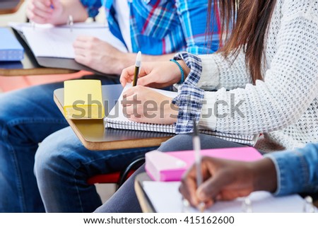 Pupils take notes with their notebooks in school