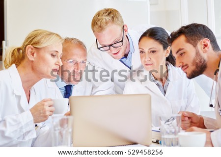 Doctors in meeting looking at computer together