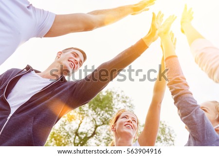Team of teenagers High Five in the air in summer as friendship and success concept