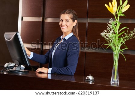 Friendly concierge at hotel reception behind the counter