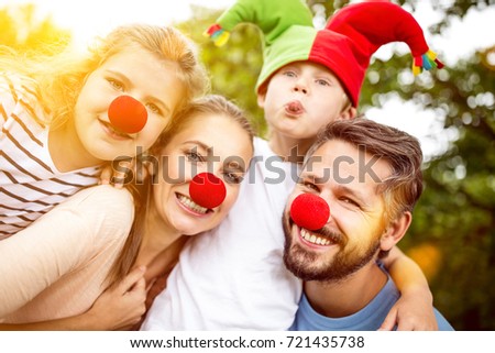 Happy family wearing clown costumes for carnival having fun