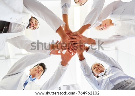 Students stack hands togehter for team spirit in cooperation for motivation as team