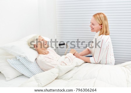 Woman makes a medical visit to bedridden senior citizen in the hospital