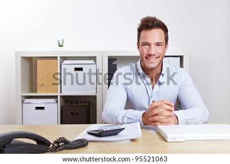 Smiling business consultant in office at desk