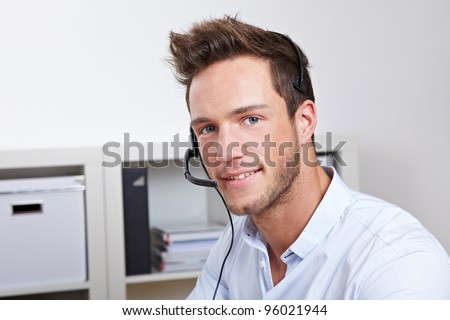 Helpful phone support agent with headset in callcenter office