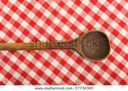Old cooking spoon on a checkered tablecloth