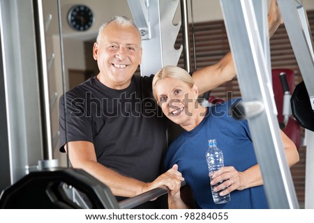 Happy senior citizens couple smiling in fitness center